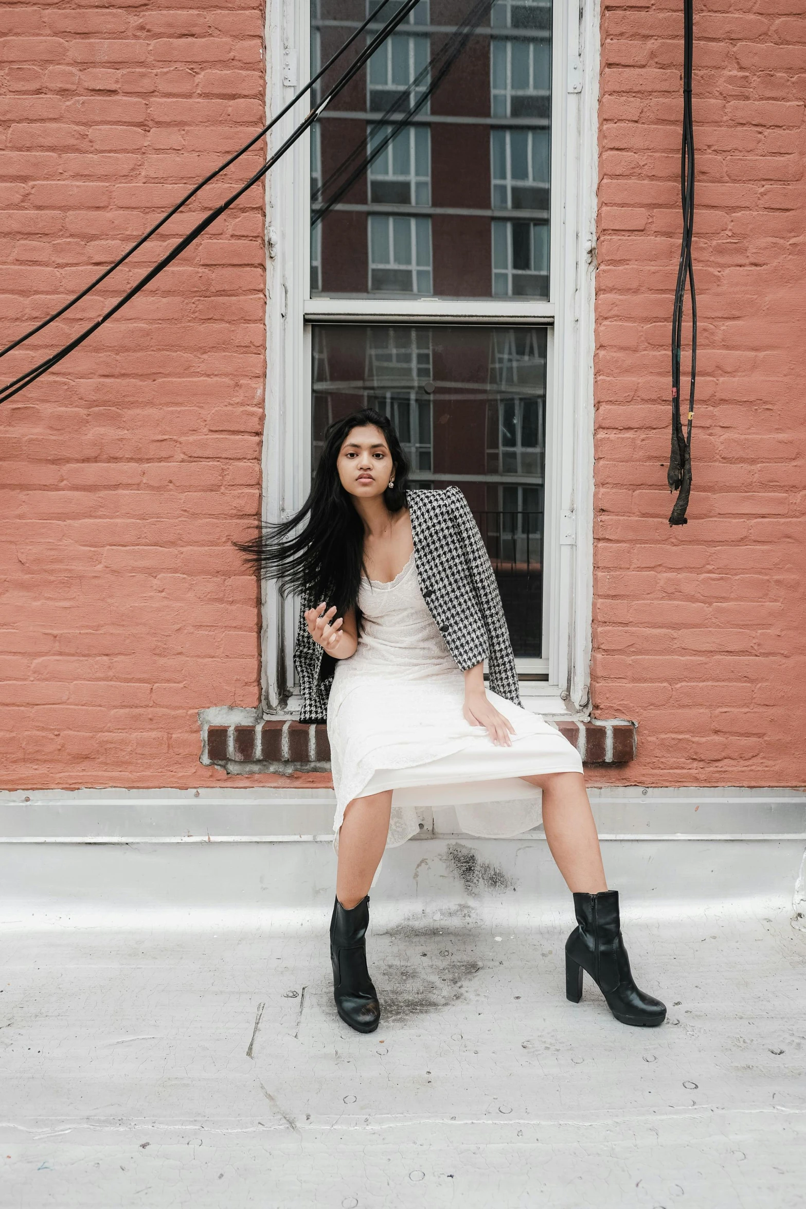 a woman sitting on the step in front of a brick building