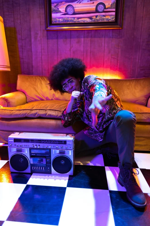 a girl is sitting on the floor with a boombox