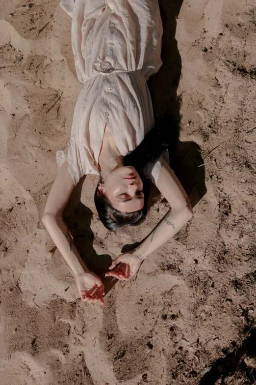 a woman lies on the beach, surrounded by sand