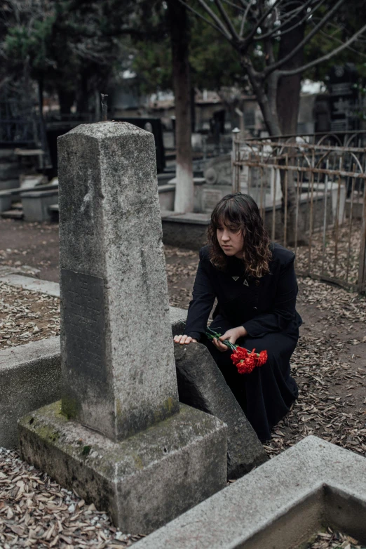 a person in a graveyard looking at the ground