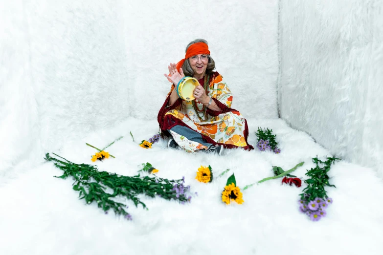 a woman poses with some wild flowers in her studio