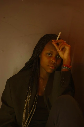a black woman sits and smokes a cigarette