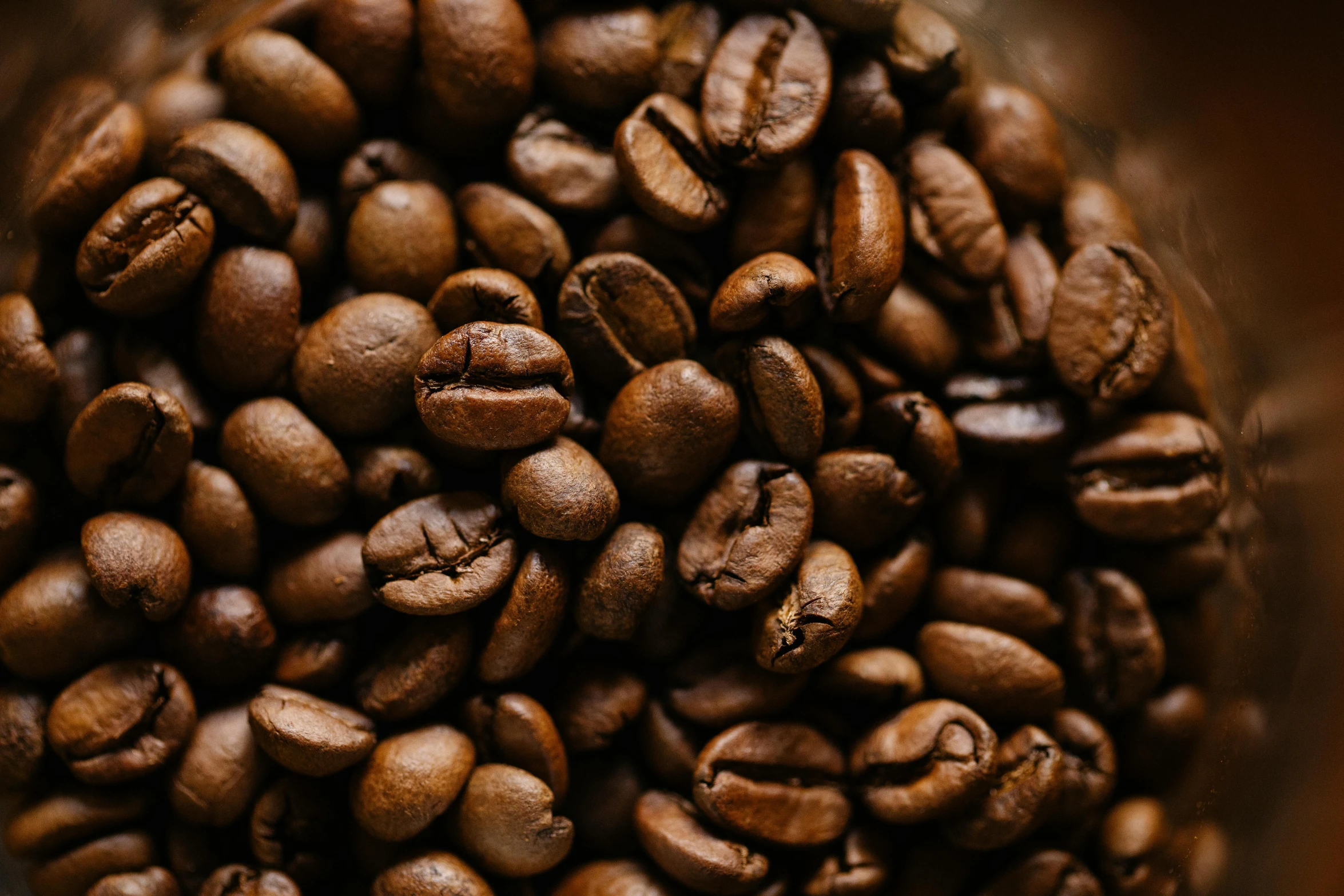 an assortment of coffee beans in a metallic cup