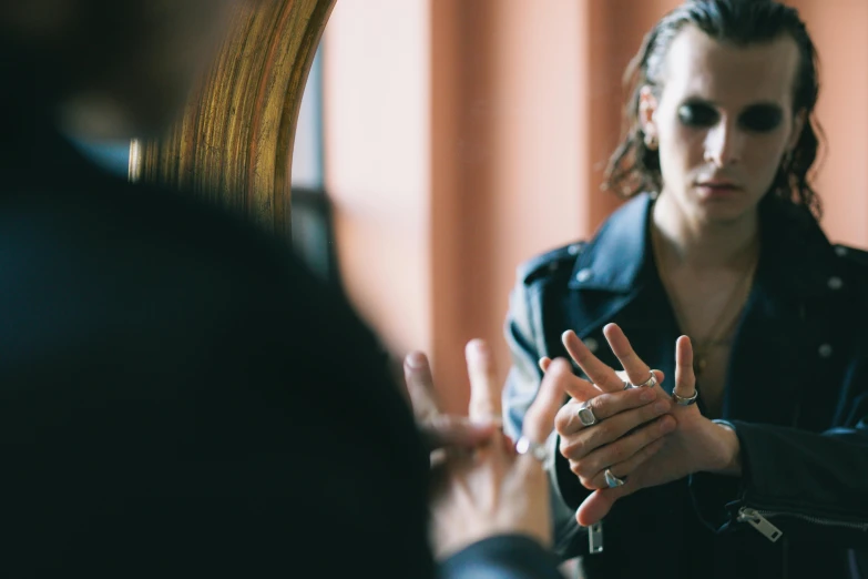 a woman is pointing her hand towards the mirror