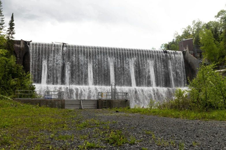 waterfall with a bench under it and the water flowing from it