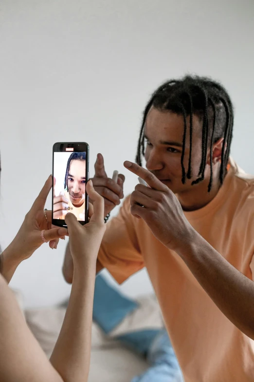 two people taking pictures with their cell phones