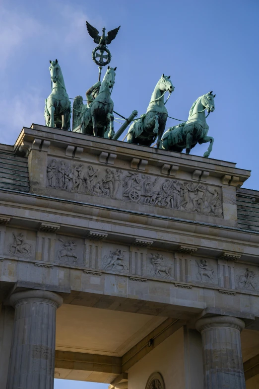 some statues sitting on top of a large white building