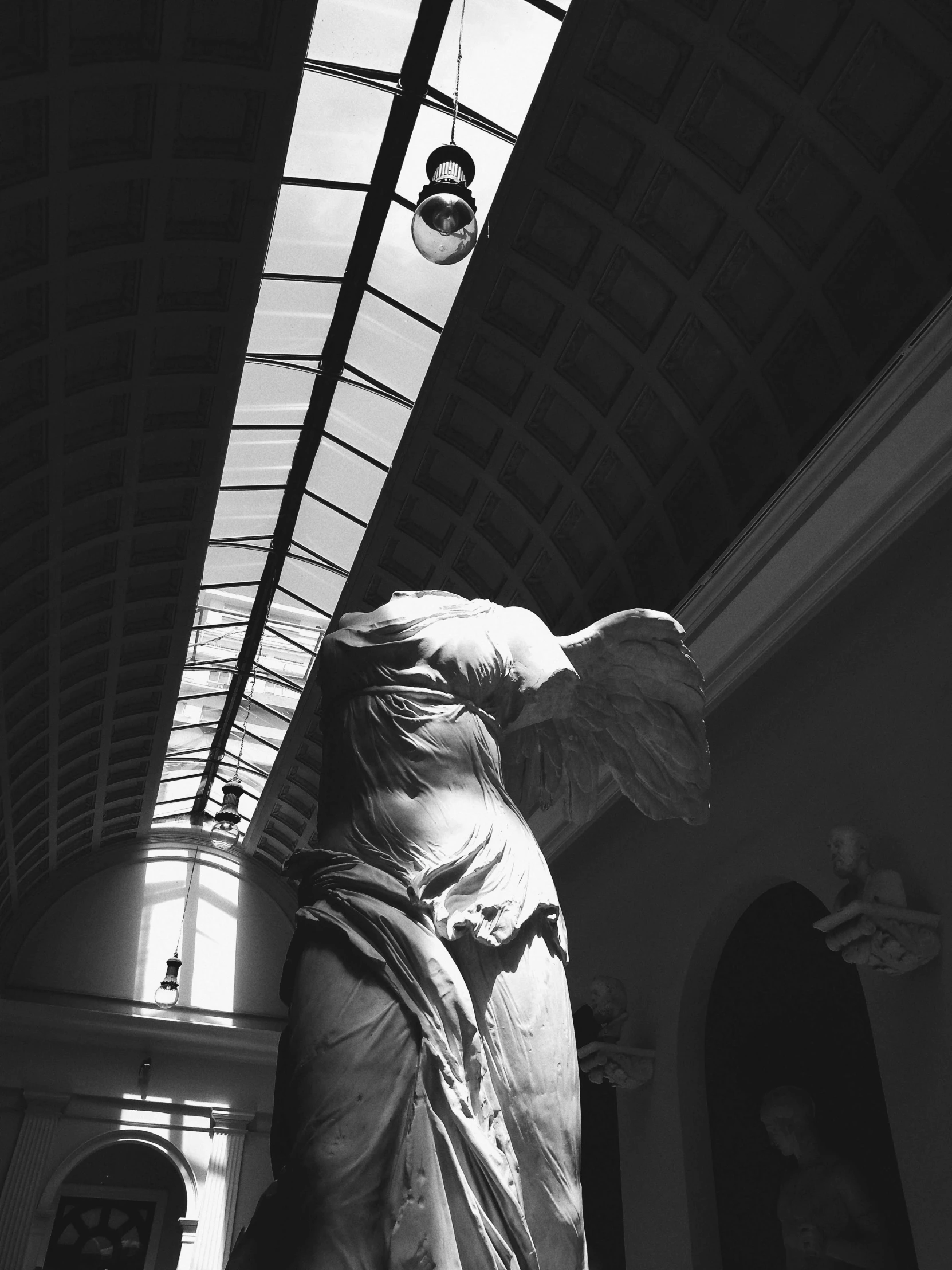 a black and white po of a statue under a ceiling