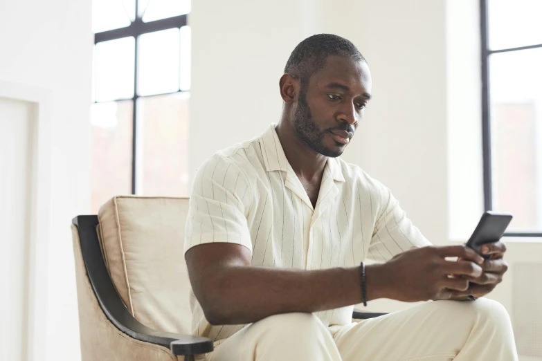 a man sitting down and looking at his cell phone