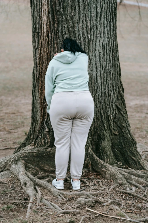 woman standing by a tree looking back