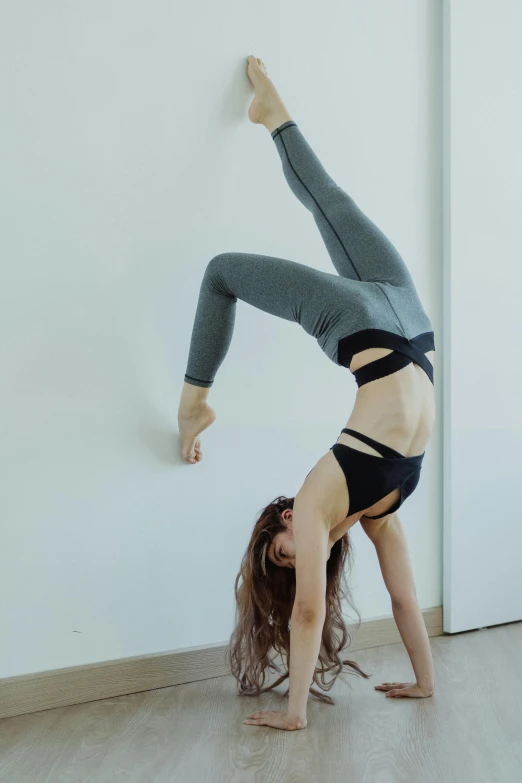 a girl wearing a high waisted underwear is stretching and balancing on one leg