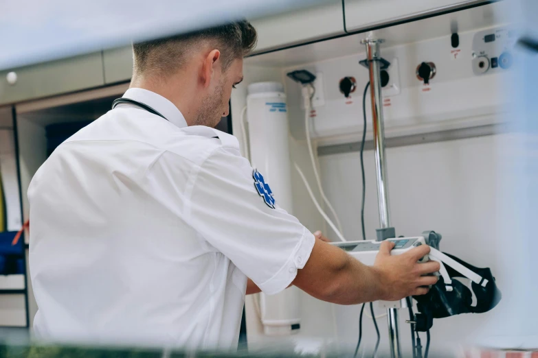 a man is working inside a building that has a sink and several pipes