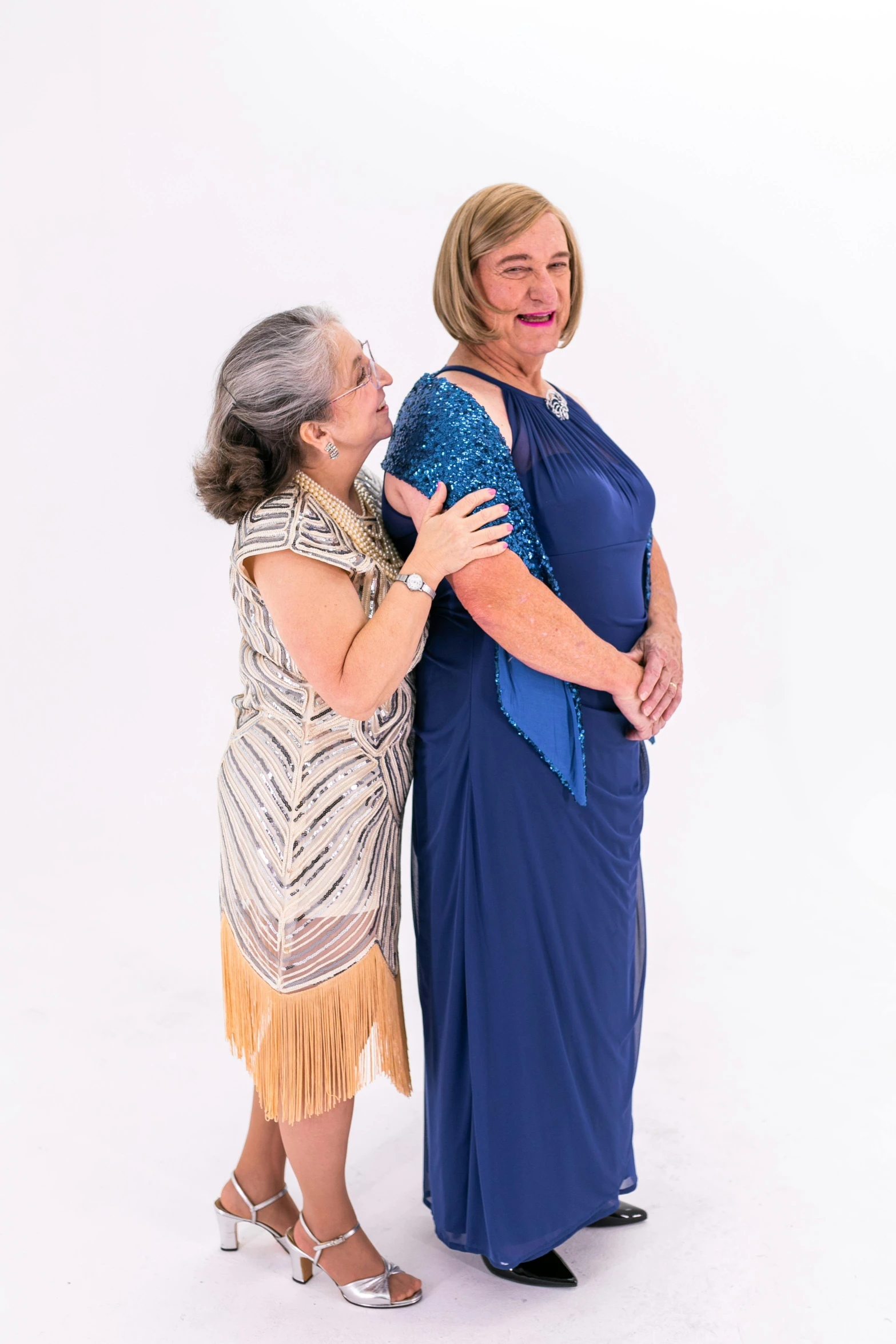 two women in formal clothes pose for a picture