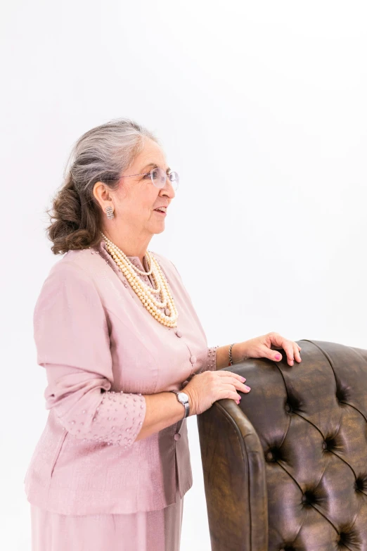 woman with pearls on a leather chair