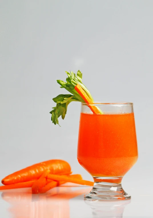 a small glass with orange juice and carrots
