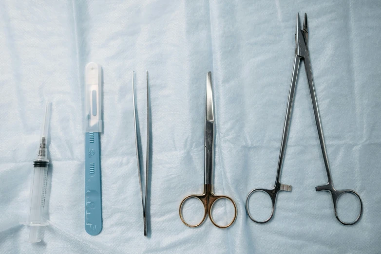 four pairs of scissors sitting side by side next to some tools