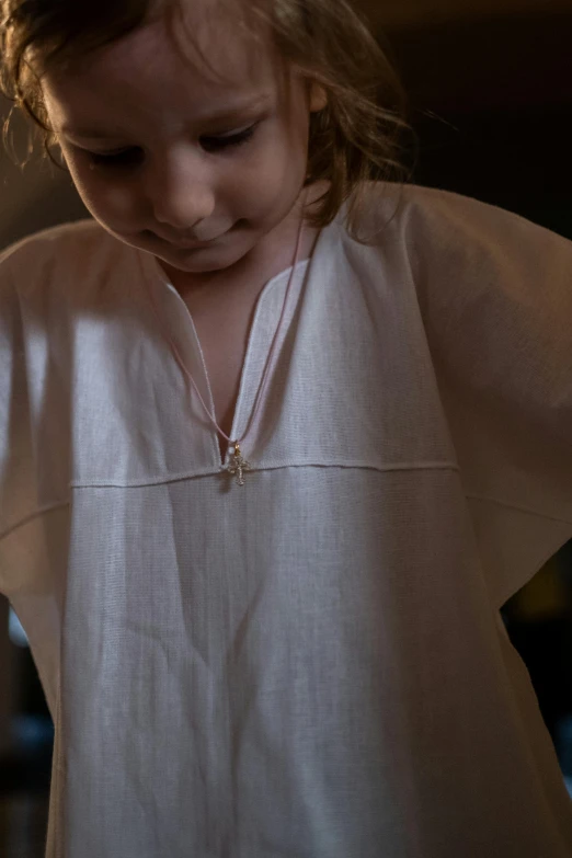 the little girl is smiling and holding onto the piece of broach