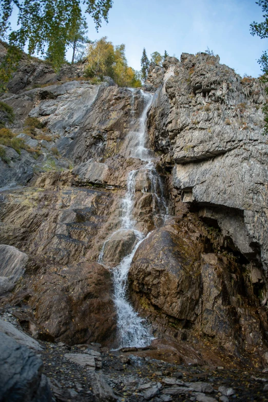 a waterfall pouring out of the side of a large cliff