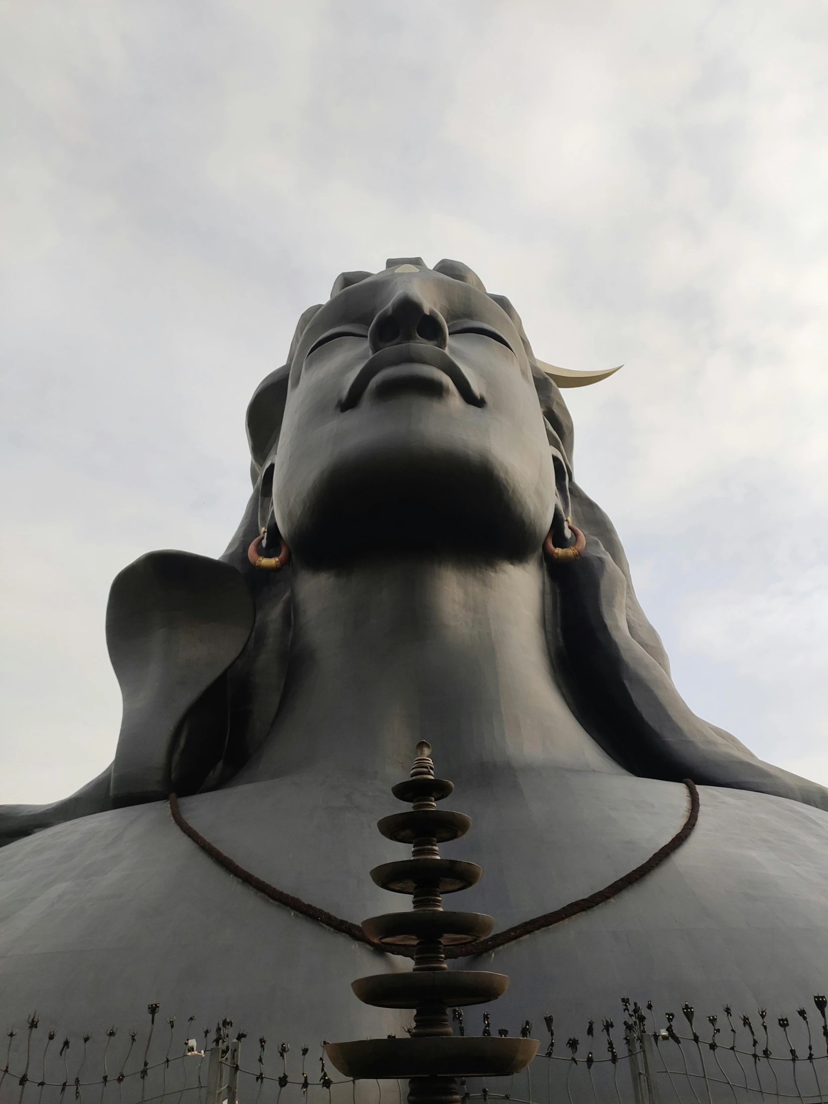 a large buddha statue with many faces painted on it's body