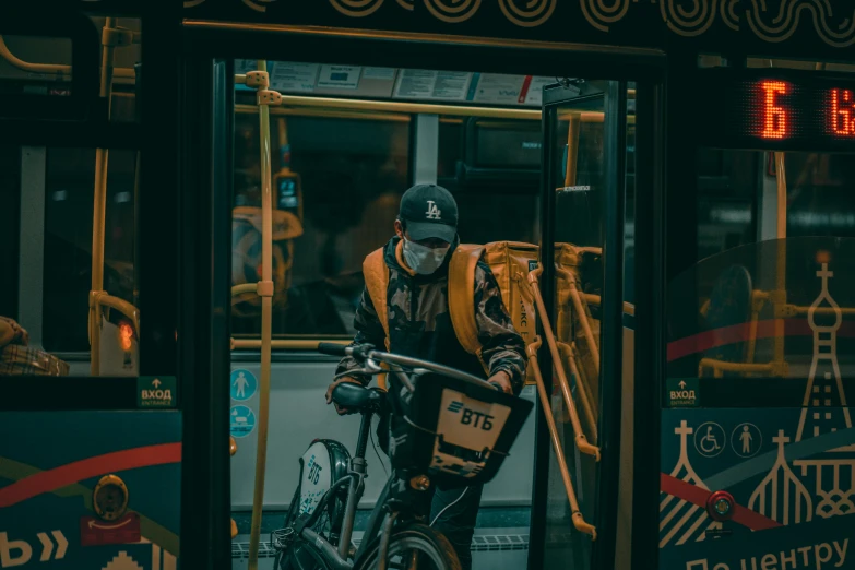 a man dressed in black and yellow standing next to his bike