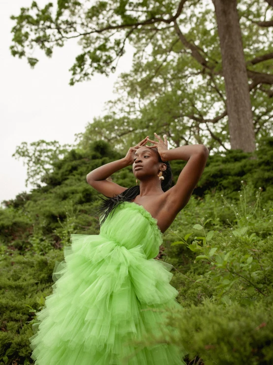 a woman is in a green dress outside