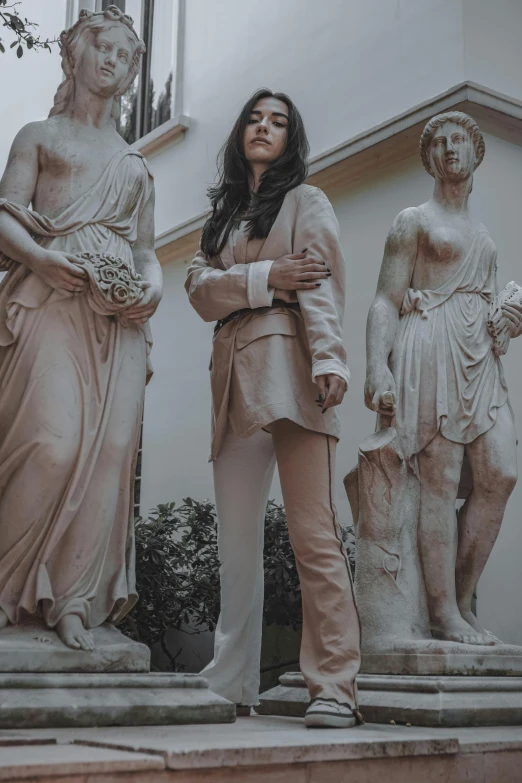 a woman standing on steps between statues