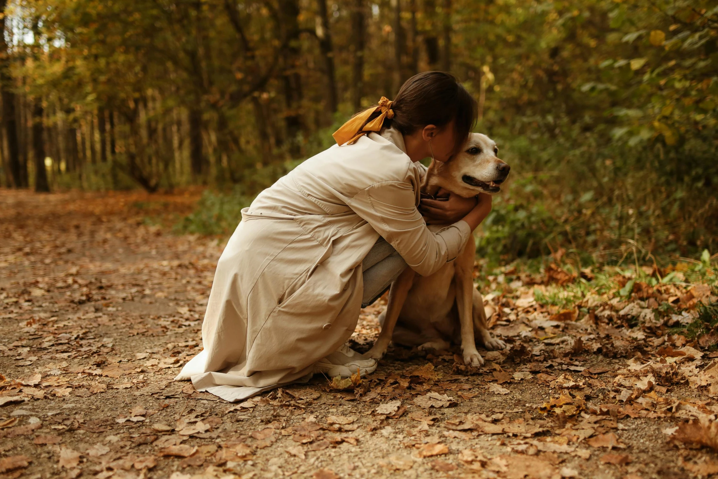 a woman in white dress hugging a dog