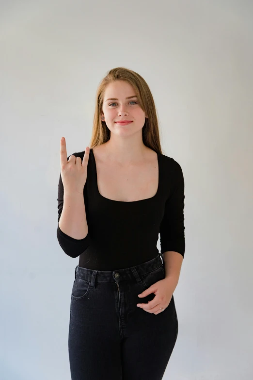 a girl giving a sign with her left hand