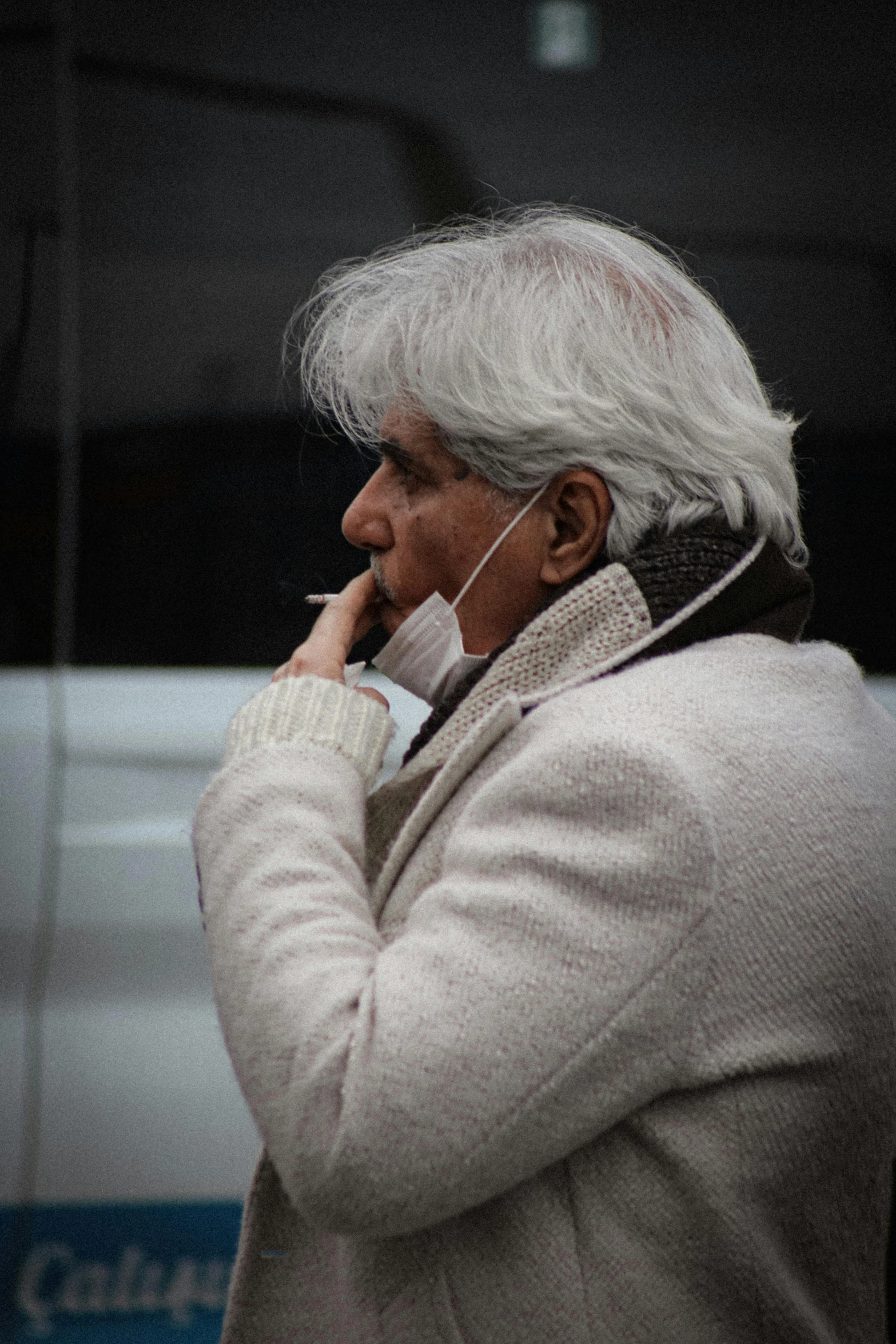 an older man standing with headphones on his ears