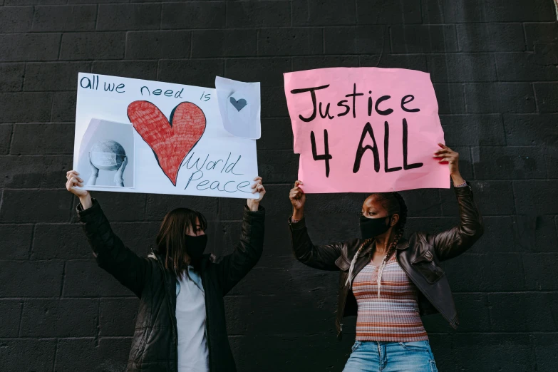 two people holding signs that say justice all