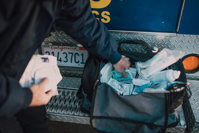 people standing around in the back of a truck with their luggage