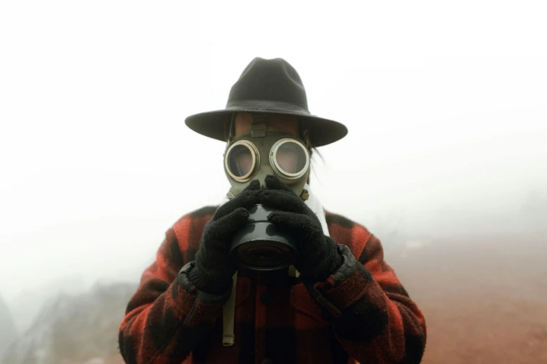 a person wearing a gas mask and holding a camera