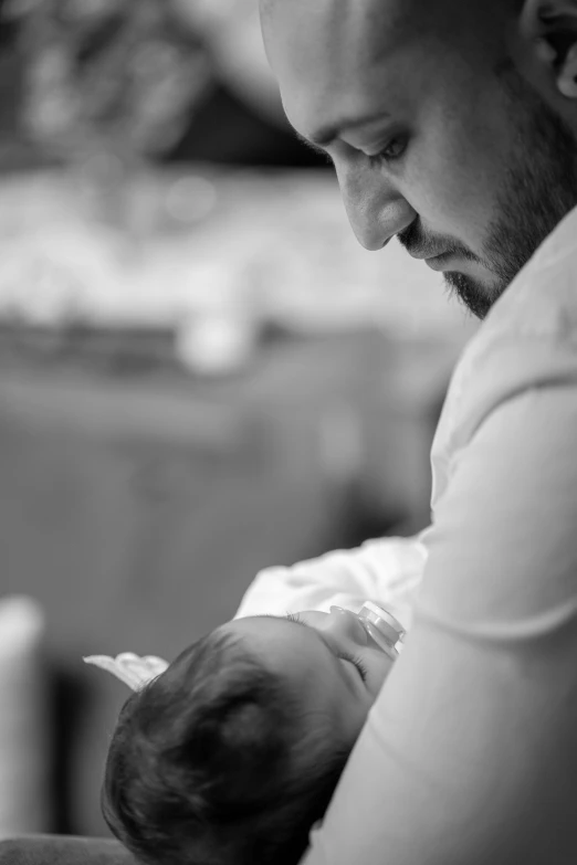 a man holding a baby while using a cellphone