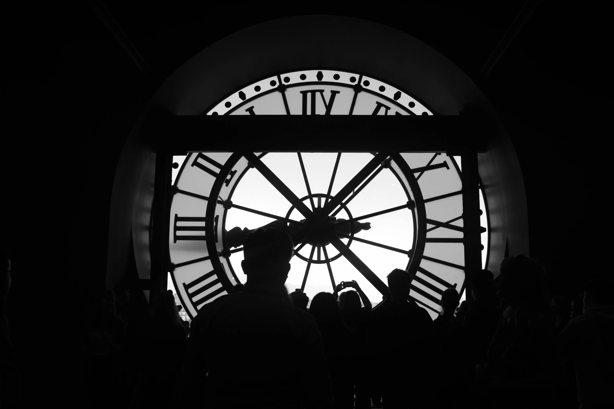 a person is taking a picture in front of a large clock