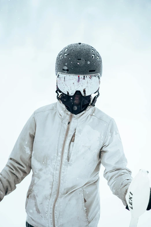 a person wearing a jacket and holding a snowboard in the snow