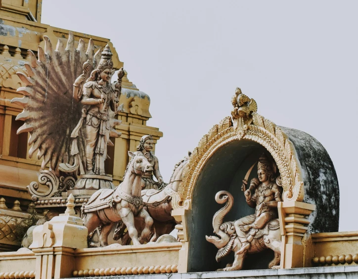 statues are standing on the roof of a building