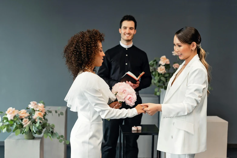 a priest and bride getting flowers from each other