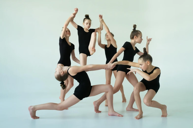 several girls are stretching, with one child doing an acrobatic move