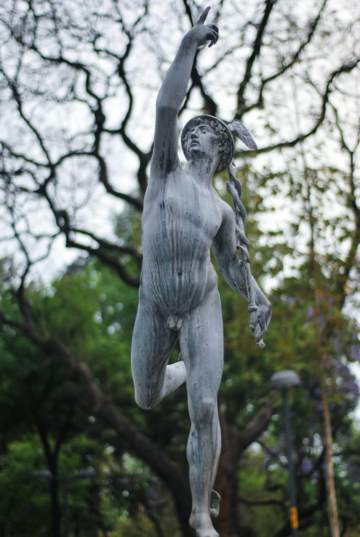 a statue standing in the middle of a park