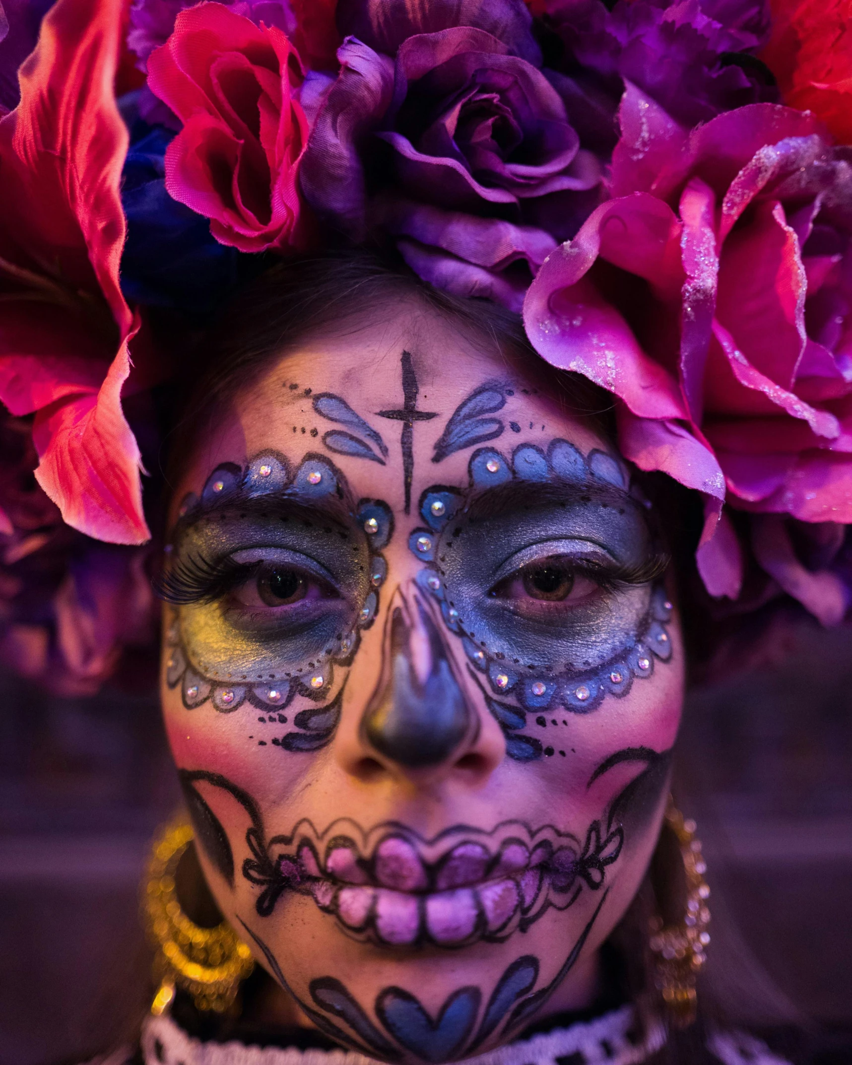 a woman wearing face paint and flowers in her hair