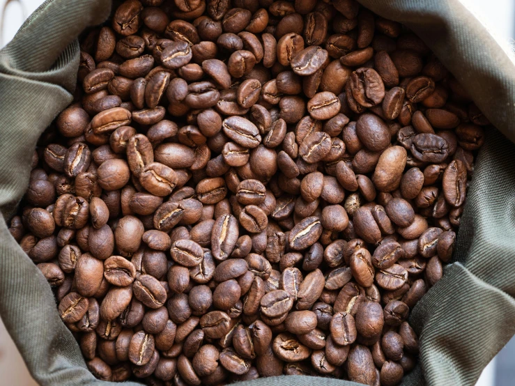 some coffee beans in a bag, spilling onto the ground