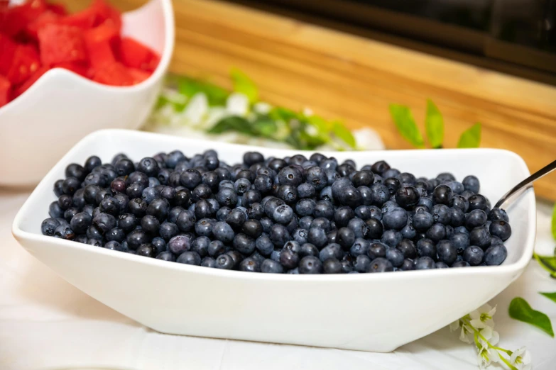 a bowl of berries is being picked up by a lader