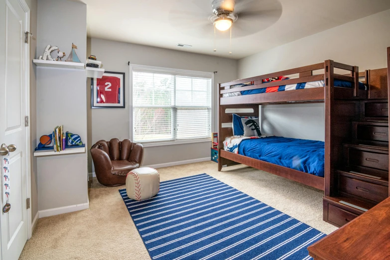 the large boy's bedroom has a baseball themed rug on the floor