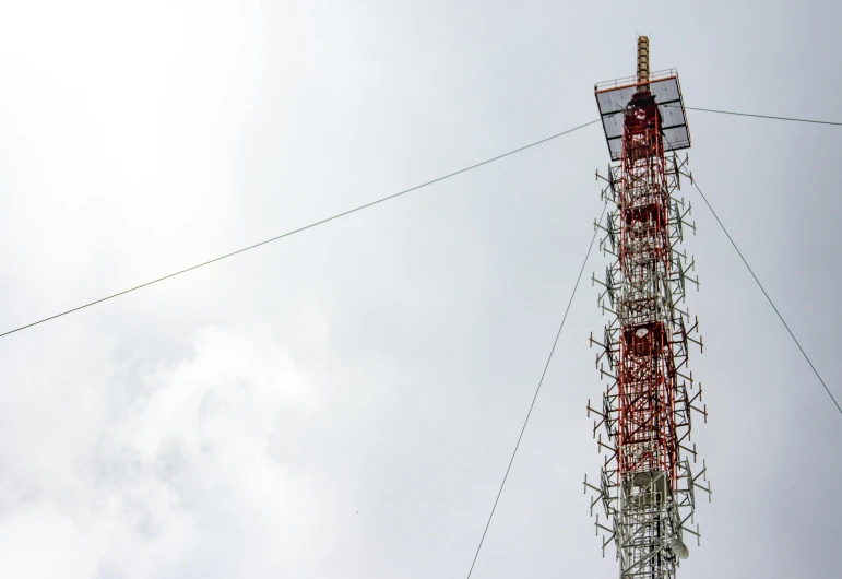 the tall tower is covered by lots of wires