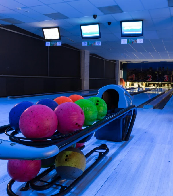 a bowling alley with many colored balls on the ground