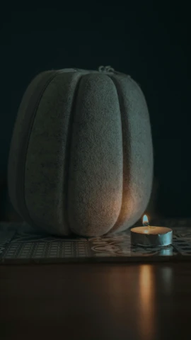 a lit candle sits on top of some fabric