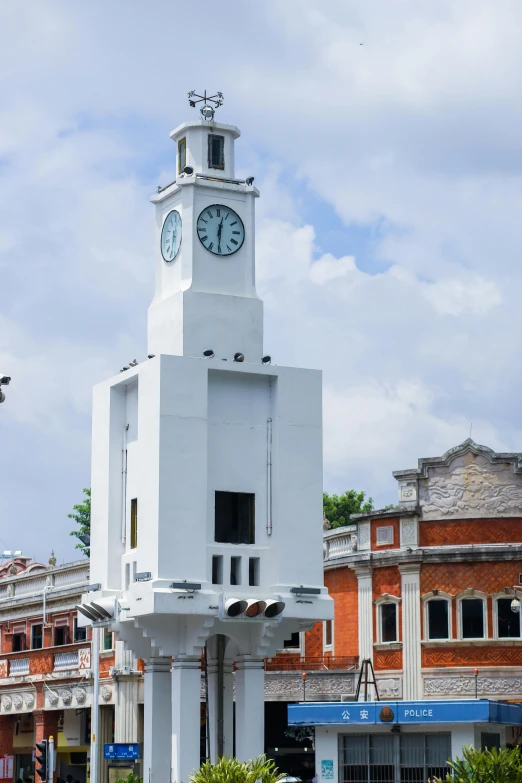 white clock tower standing in front of a red brick building