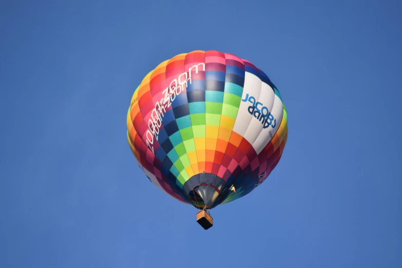 the multi colored  air balloon is flying