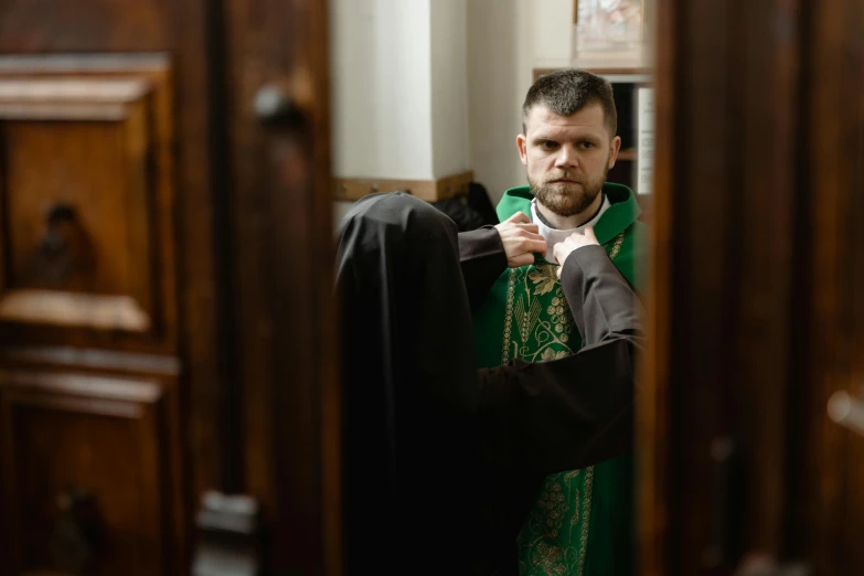 the priest is fixing the robe on his coat