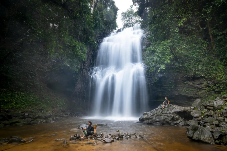 some people are in front of a large waterfall